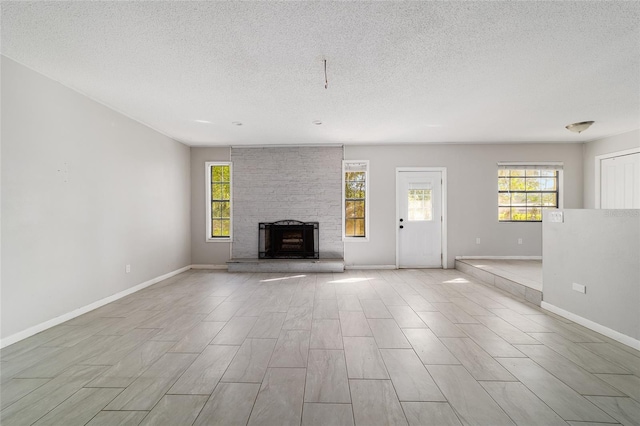 9951 NE 30th Ct, Anthony, FL 32617 - unfurnished living room featuring baseboards, a large fireplace, and a textured ceiling