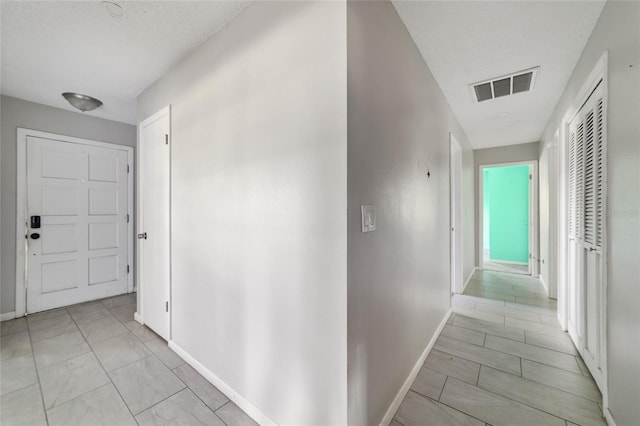 9951 NE 30th Ct, Anthony, FL 32617 - hall featuring baseboards, a textured ceiling, and visible vents