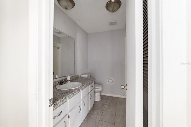 9951 NE 30th Ct, Anthony, FL 32617 - full bathroom with toilet, vanity, a textured ceiling, baseboards, and visible vents