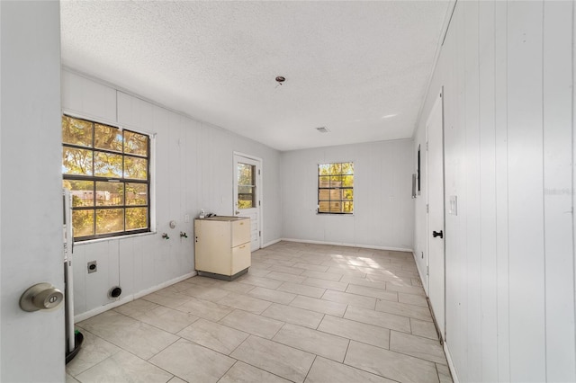 9951 NE 30th Ct, Anthony, FL 32617 - empty room featuring baseboards, a healthy amount of sunlight, and a textured ceiling