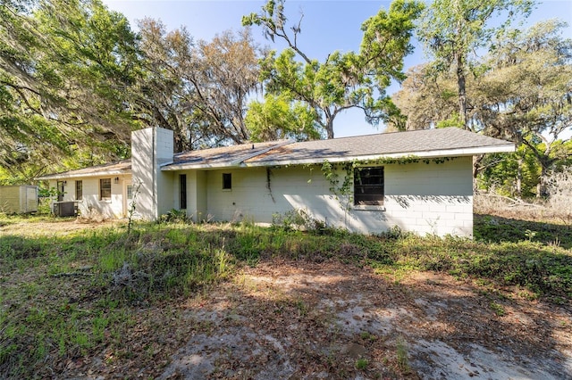 9951 NE 30th Ct, Anthony, FL 32617 - back of property with concrete block siding, a chimney, and cooling unit
