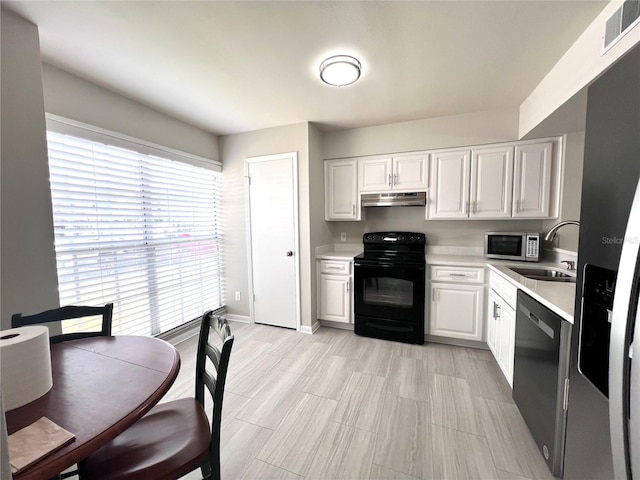 kitchen featuring visible vents, under cabinet range hood, stainless steel microwave, black range with electric cooktop, and light countertops