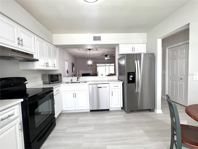 kitchen with visible vents, a sink, light countertops, under cabinet range hood, and appliances with stainless steel finishes