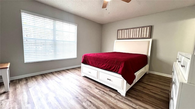 bedroom with ceiling fan, baseboards, a textured ceiling, and wood finished floors