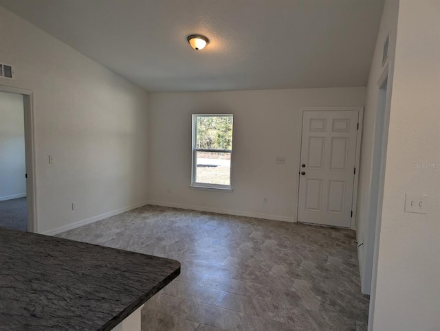 unfurnished dining area with baseboards and visible vents