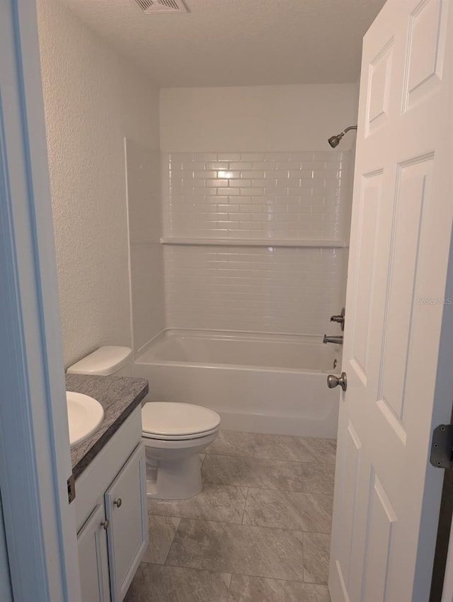 full bathroom featuring toilet,  shower combination, vanity, and a textured wall