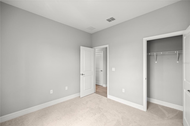 unfurnished bedroom with baseboards, visible vents, a closet, and carpet flooring