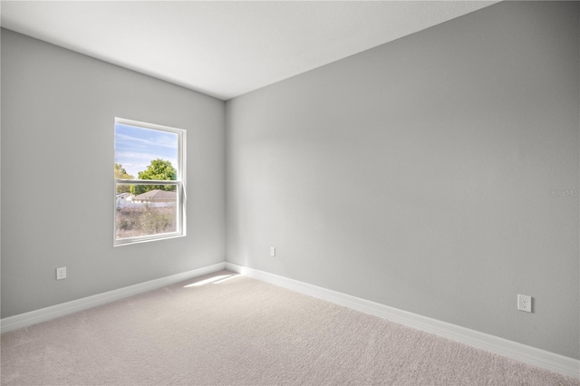 carpeted empty room with baseboards