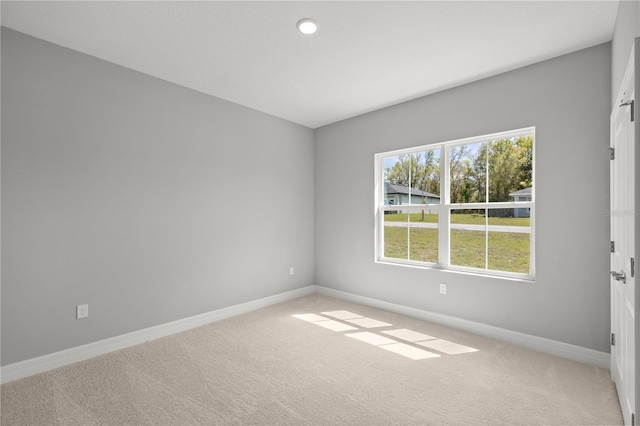 carpeted empty room featuring baseboards and recessed lighting