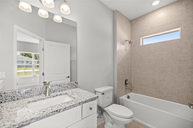 full bath featuring toilet, vanity, a healthy amount of sunlight, and washtub / shower combination