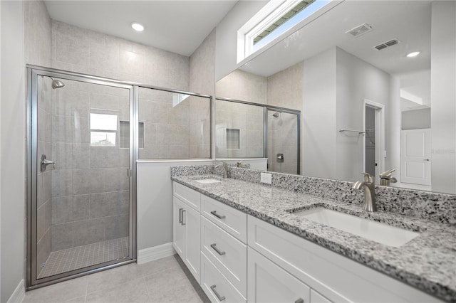 full bathroom featuring tile patterned flooring, a sink, a shower stall, and visible vents