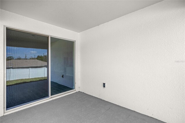 empty room with concrete floors and a textured wall