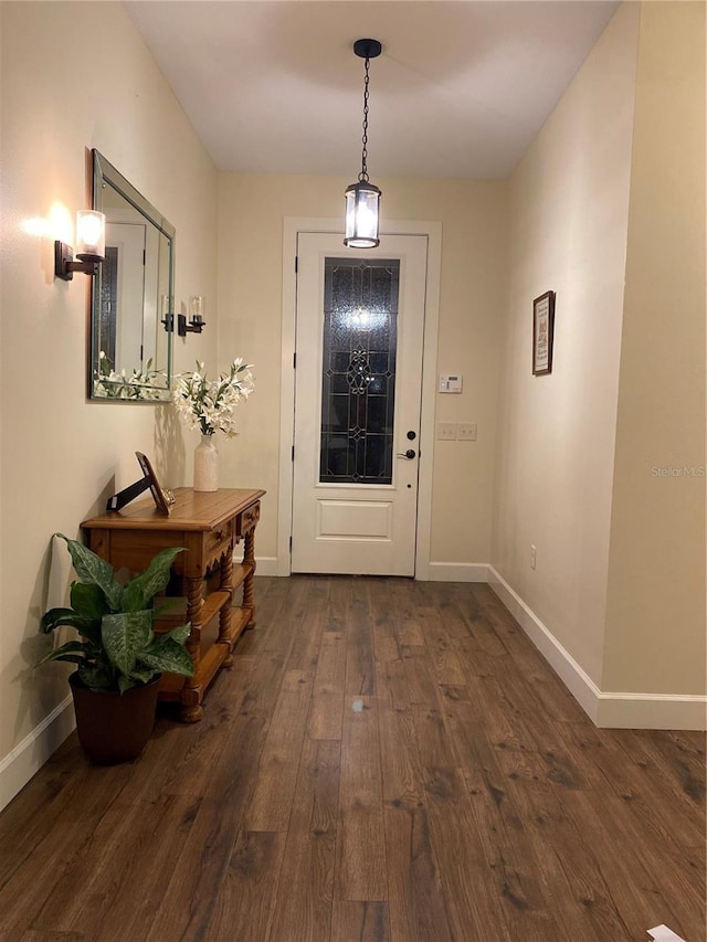 entryway with dark wood finished floors and baseboards