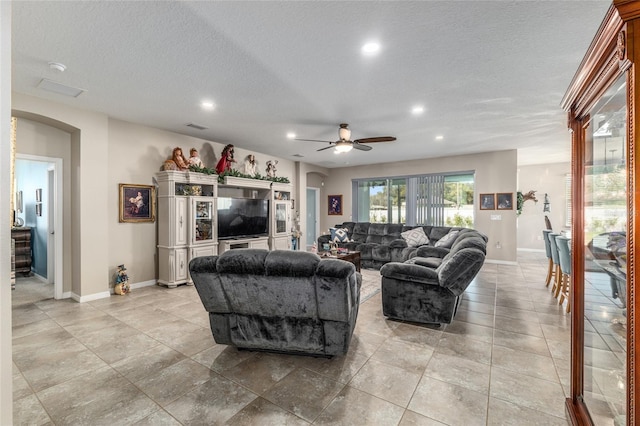 living room with recessed lighting, arched walkways, a textured ceiling, and a ceiling fan