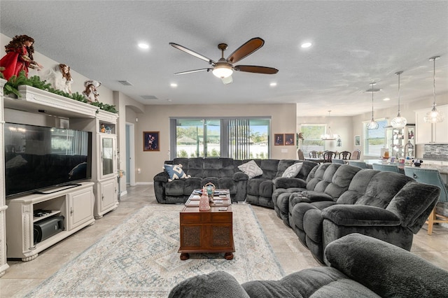 living area with recessed lighting, visible vents, a textured ceiling, and a ceiling fan