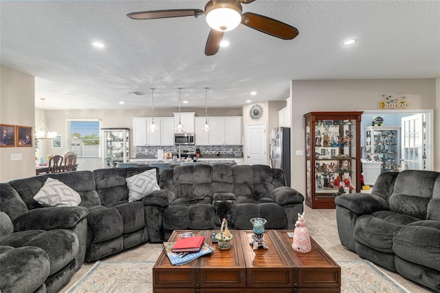 living room featuring recessed lighting, a textured ceiling, and ceiling fan