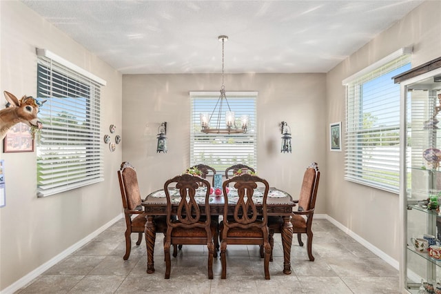 dining area featuring baseboards and a chandelier