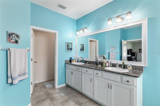 full bathroom featuring double vanity, baseboards, visible vents, and a sink