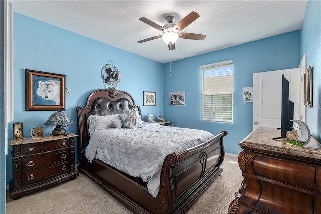 bedroom with light carpet, baseboards, a textured ceiling, and a ceiling fan