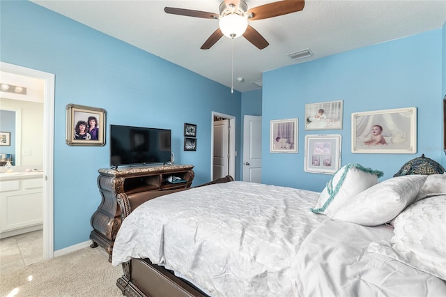 bedroom featuring visible vents, light carpet, ensuite bathroom, baseboards, and ceiling fan