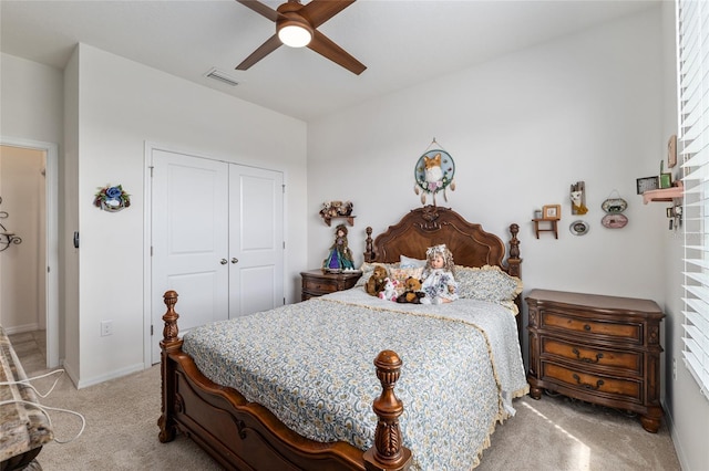 bedroom featuring visible vents, baseboards, ceiling fan, light colored carpet, and a closet