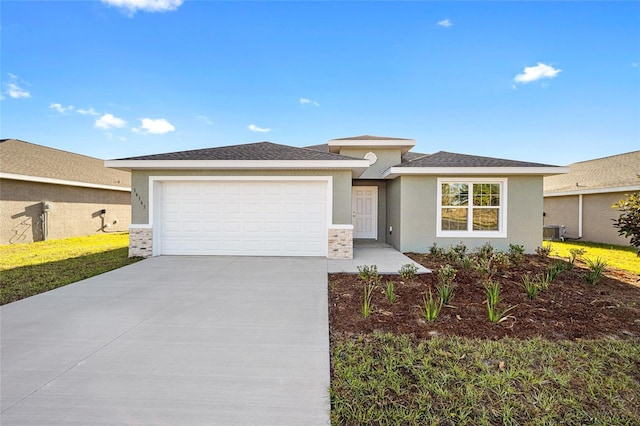 prairie-style home with central AC unit, stucco siding, driveway, and a garage