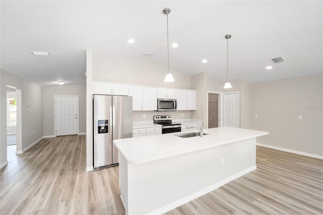 kitchen with visible vents, vaulted ceiling, stainless steel appliances, white cabinetry, and a sink