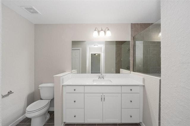 full bathroom with visible vents, baseboards, toilet, a tile shower, and vanity