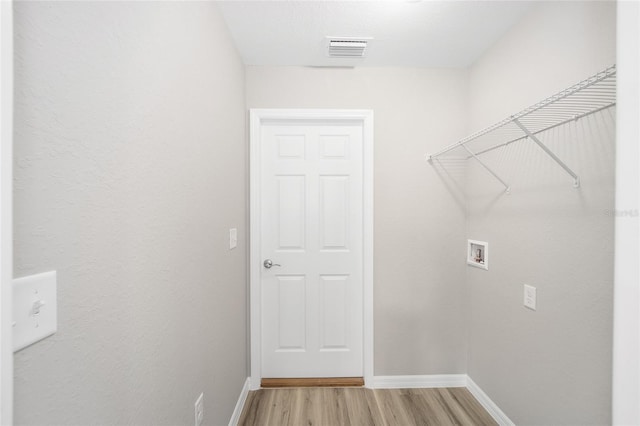 washroom with visible vents, baseboards, laundry area, hookup for a washing machine, and light wood-style floors