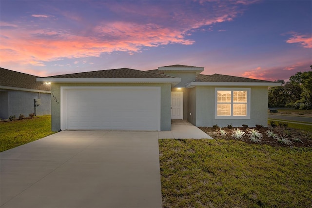 view of front facade with a garage, a front lawn, driveway, and stucco siding