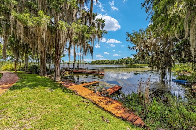 dock area featuring a lawn and a water view