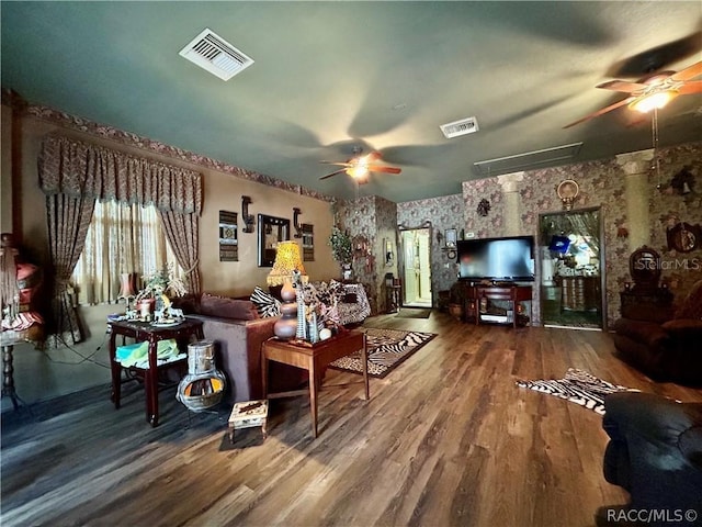 living area with visible vents, ceiling fan, and wood finished floors