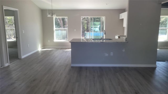 kitchen with a sink, a healthy amount of sunlight, dark wood-style floors, and white cabinetry