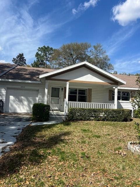 single story home with aphalt driveway, covered porch, a front yard, and a garage