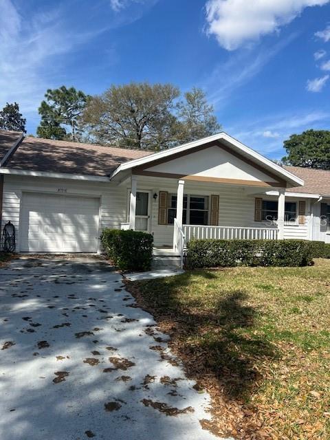 ranch-style home with covered porch, a garage, and driveway