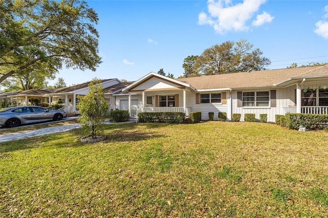 ranch-style home featuring a porch, board and batten siding, concrete driveway, a front yard, and an attached garage