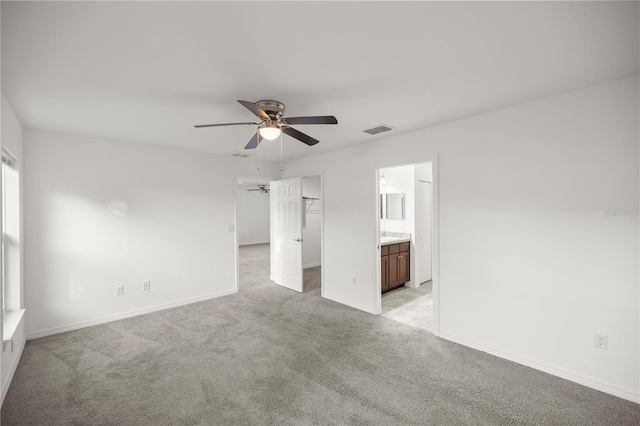 unfurnished room with visible vents, baseboards, light colored carpet, and a ceiling fan