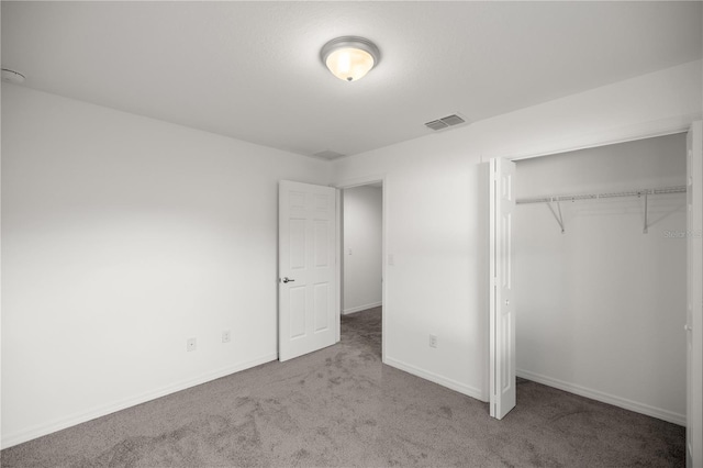 unfurnished bedroom featuring carpet flooring, visible vents, a closet, and baseboards