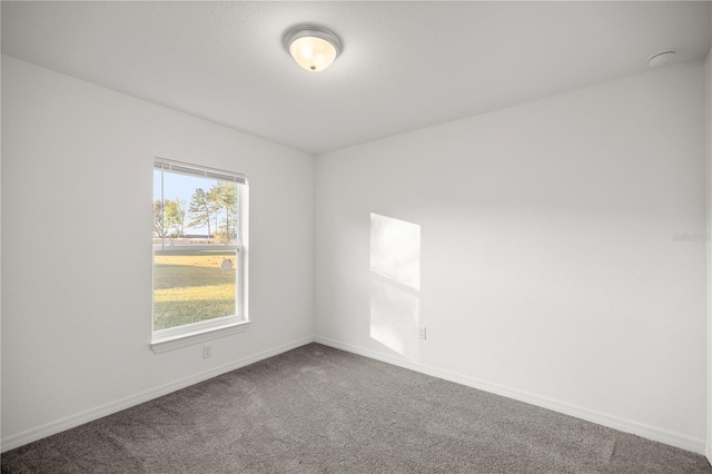 carpeted spare room featuring baseboards