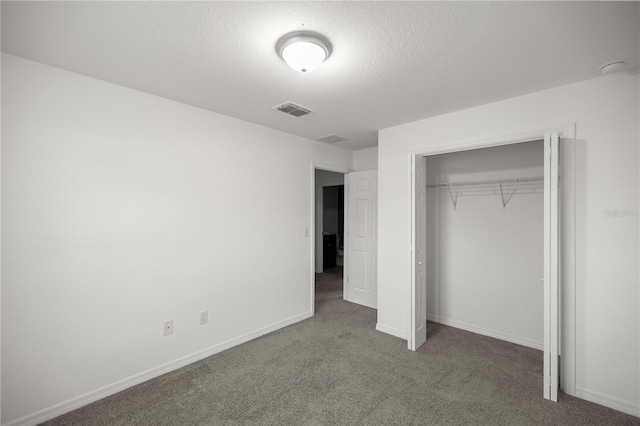 unfurnished bedroom with visible vents, baseboards, carpet flooring, a closet, and a textured ceiling