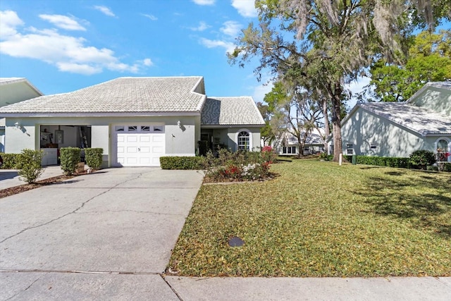 view of front of property featuring stucco siding, a front yard, concrete driveway, and an attached garage