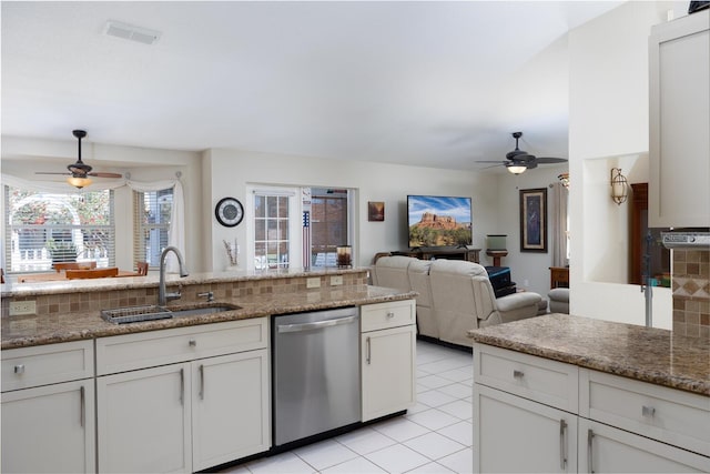 kitchen featuring dishwasher, decorative backsplash, a sink, and ceiling fan