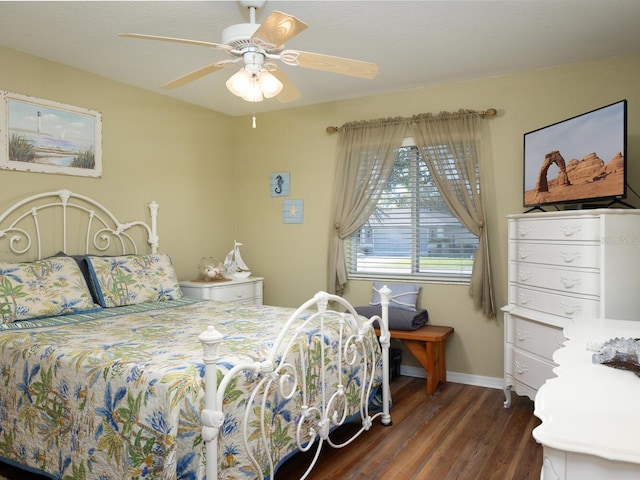 bedroom featuring dark wood finished floors, a ceiling fan, and baseboards