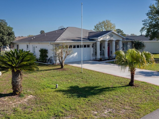 view of front of house featuring an attached garage, concrete driveway, and a front yard