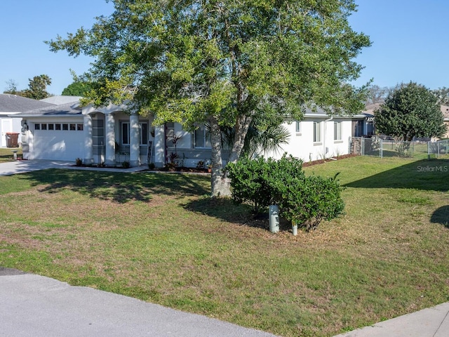 view of front of house featuring driveway, a front lawn, a garage, and fence