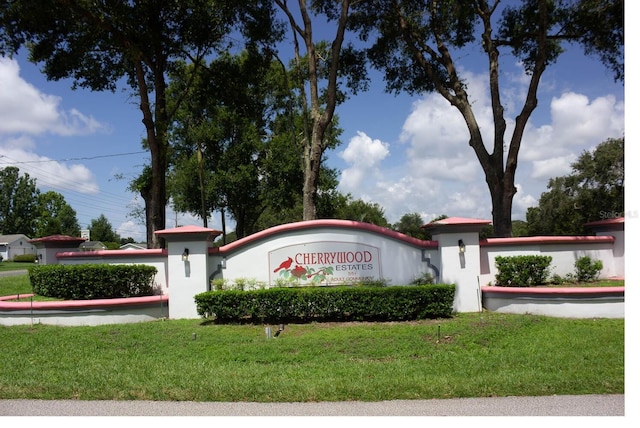 community / neighborhood sign featuring a yard