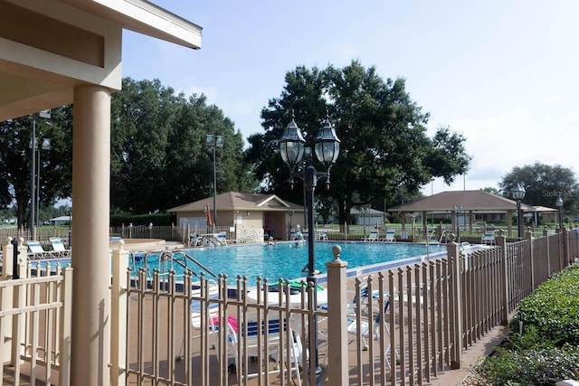 community pool with a patio area and fence