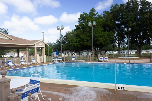 community pool featuring a patio area and fence