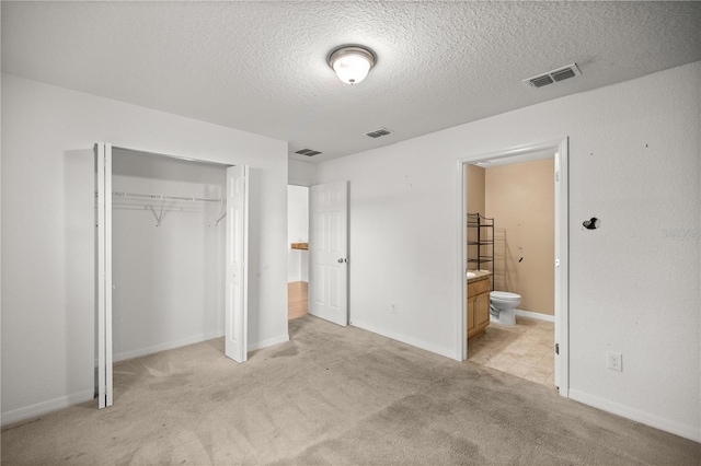 unfurnished bedroom featuring a closet, visible vents, and light colored carpet