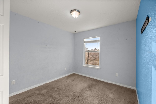 spare room featuring baseboards and carpet floors